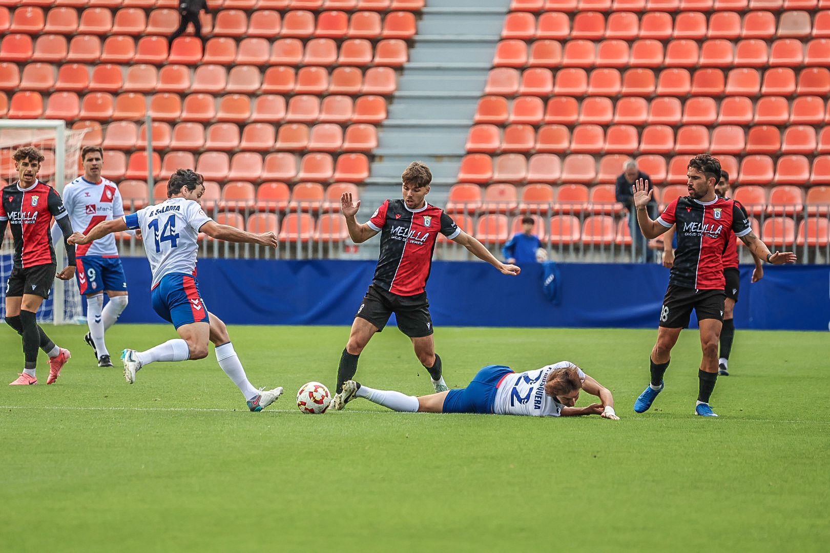 Jugadores del Rayo Majadahonda y UD Melilla disputan el balón