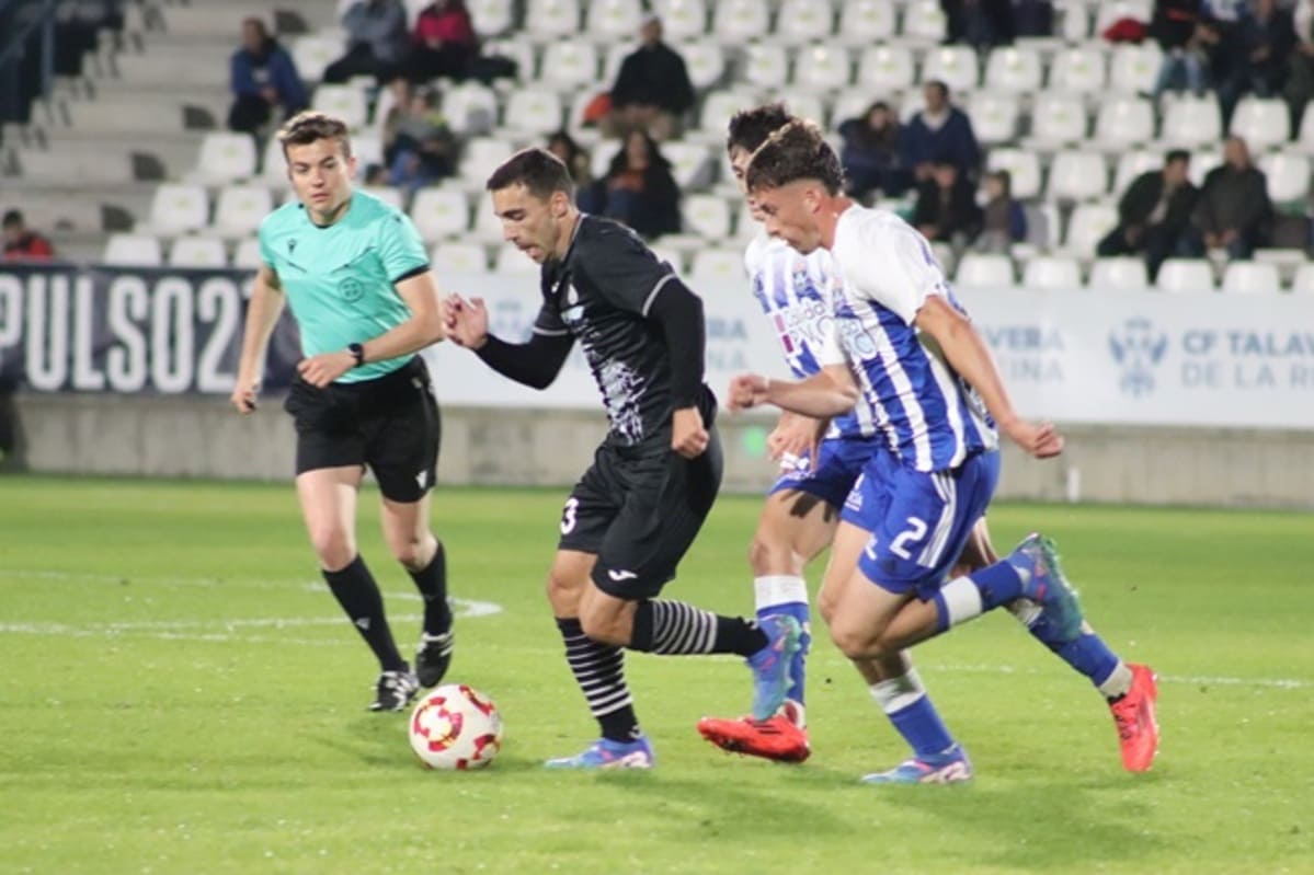 Jugadores de Talavera y Conquense disputando el balón